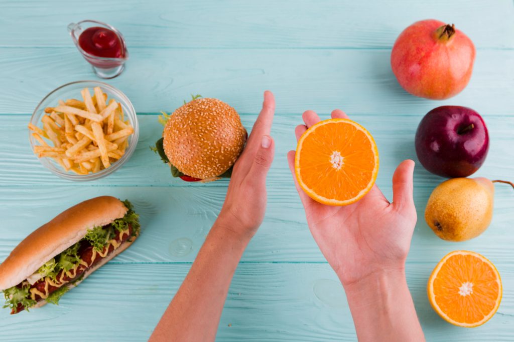 Copilul alege o portocală în locul alimentelor de tip fast-food
